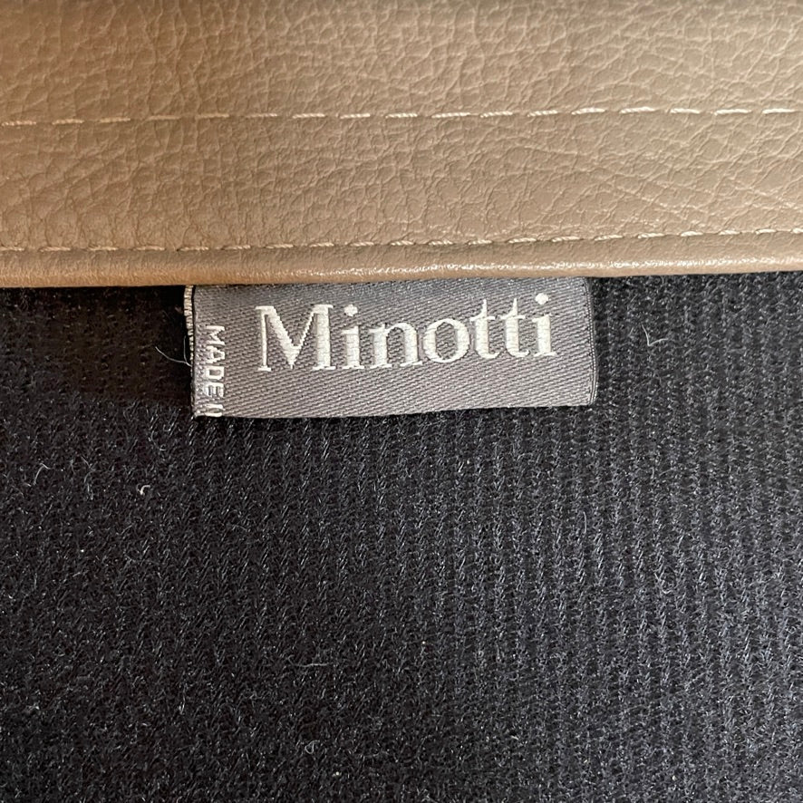 A pair of Minotti Aston Counter Stools, featuring beige cushioned backs and seats supported by sleek black-finished solid ash legs, is displayed against a plain background.