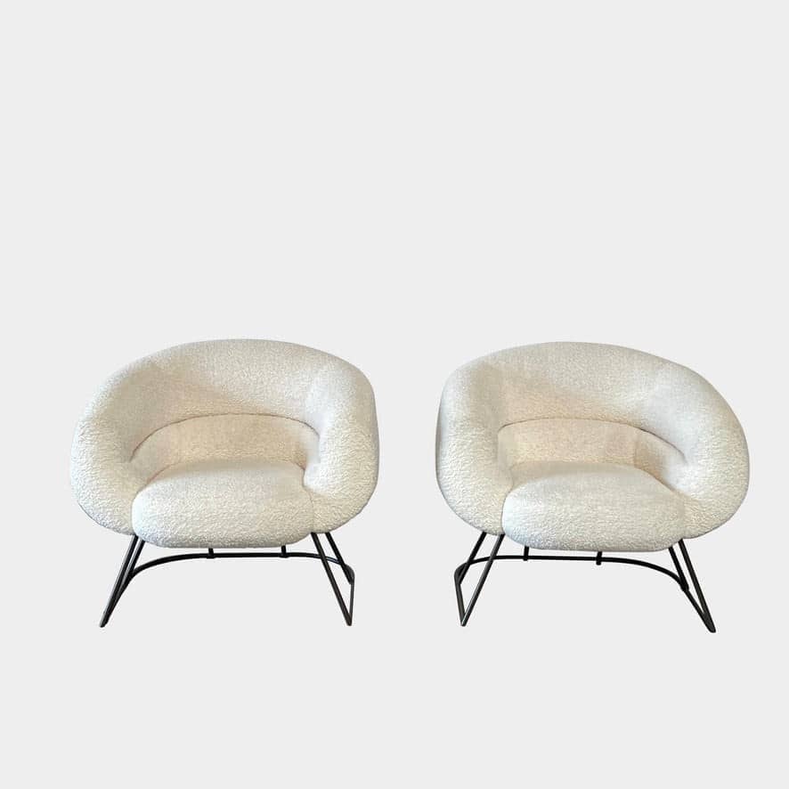 A pair of white Delcourt Collection DJE armchairs.