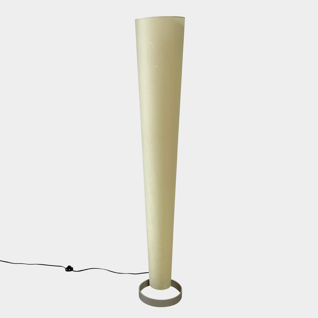 A modern, cone-shaped beige Pallucco Italia Abat Jour Floor Light by Pallucco Italia features a round base and a visible power cord, blending sleek design with Italian craftsmanship.