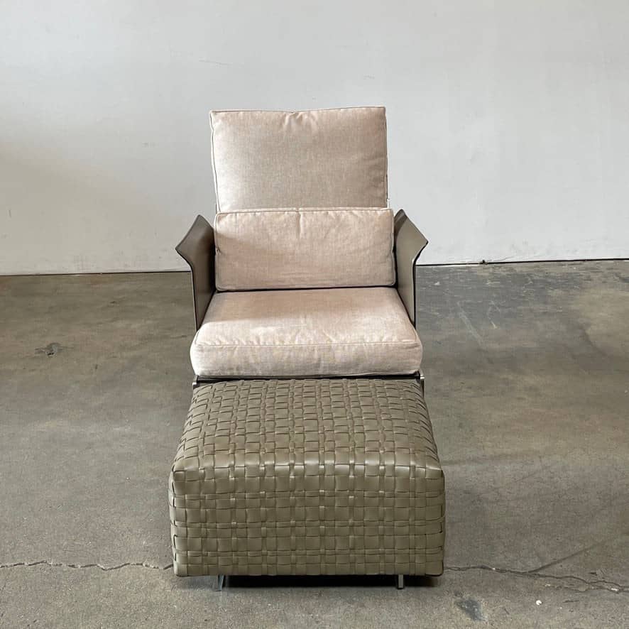 A square, beige Flexform Bangkok Ottoman with a woven leather pattern and four short metal legs evokes the stylish charm of Bangkok.