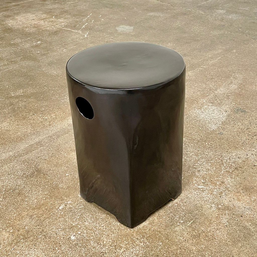 Discover the elegance of the Artelano Tian Di Ceramic Stool, crafted by Artelano using modern techniques. This glossy black stool features a square shape with rounded edges and a circular cutout near the top, combining functionality with style.