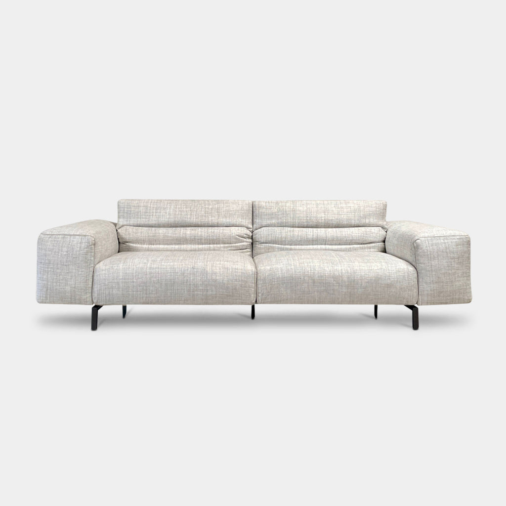 The Cassina 204 Scighera Three Seater Sofa by Cassina, designed by Piero Lissoni, showcases a minimalist design with its modern light gray upholstery and sleek black legs against a plain background.