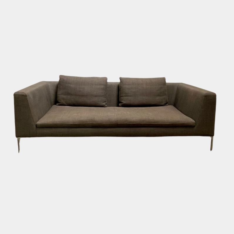 The luxurious B&B Italia Charles Sofa by B&B Italia, a modern brown piece with two seat cushions and two back cushions, boasts straight armrests and thin metal legs. It is elegantly placed against a plain white background.