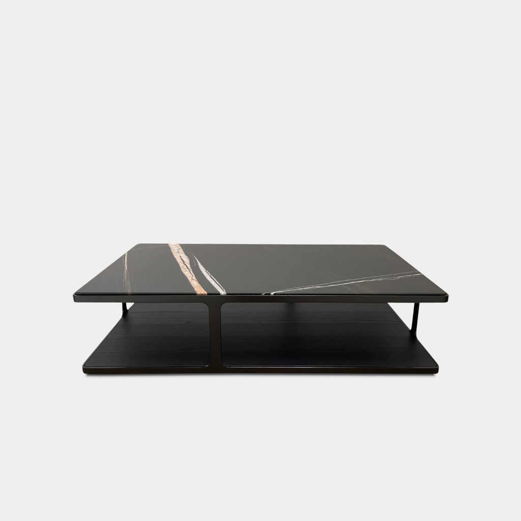 The Poliform Creek Marble Coffee Table by Poliform showcases a striking rectangular black marble surface adorned with intricate white and brown vein patterns, all elegantly supported by a brushed brown nickel frame that enhances its sophisticated design.