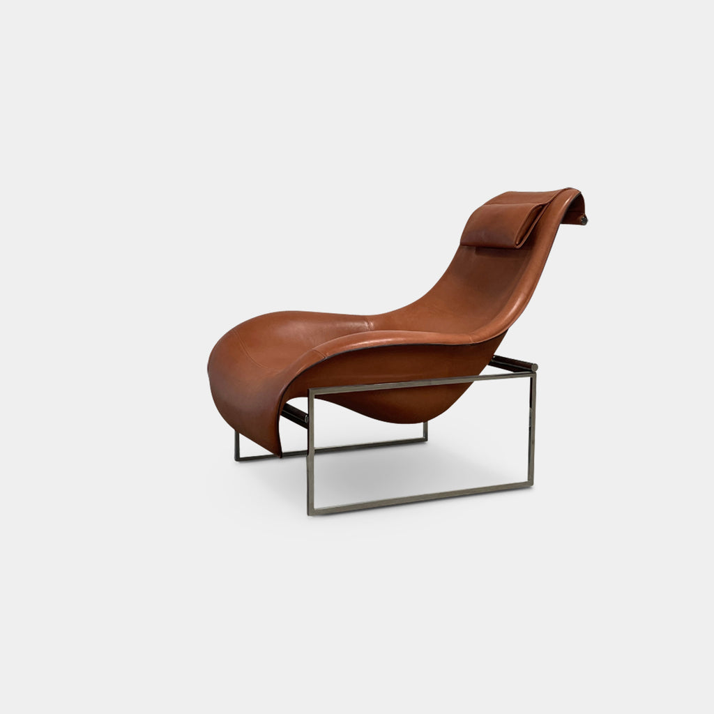 A contemporary brown leather B&B Italia Mart Reclining Armchair, featuring a headrest, is positioned against a minimal gray wall and concrete floor.