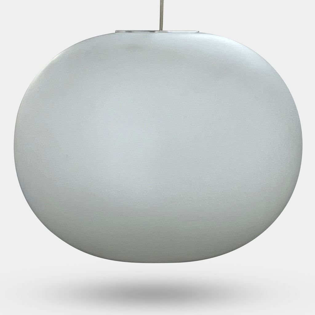 A Flos Glo-Ball S2 Pendant by Flos hangs elegantly from the ceiling, its white, spherical design set against a plain gray background.