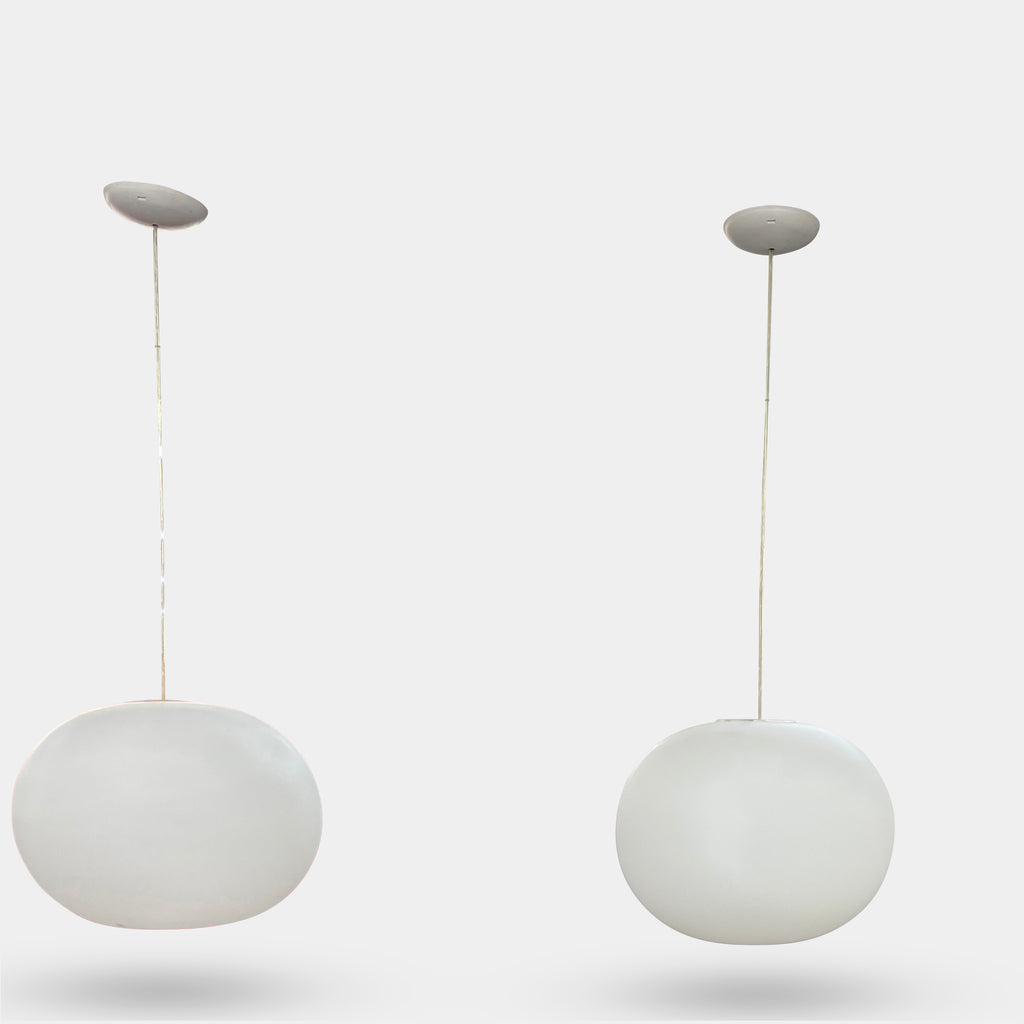 A Flos Glo-Ball S2 Pendant by Flos hangs elegantly from the ceiling, its white, spherical design set against a plain gray background.