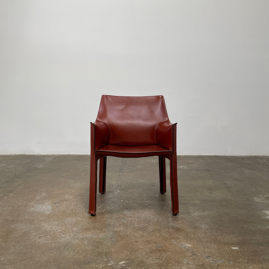 The Cassina Cab 413 Armchair in vibrant red leather presents a modern design with a high back and square legs, elegantly displayed against a plain white background.