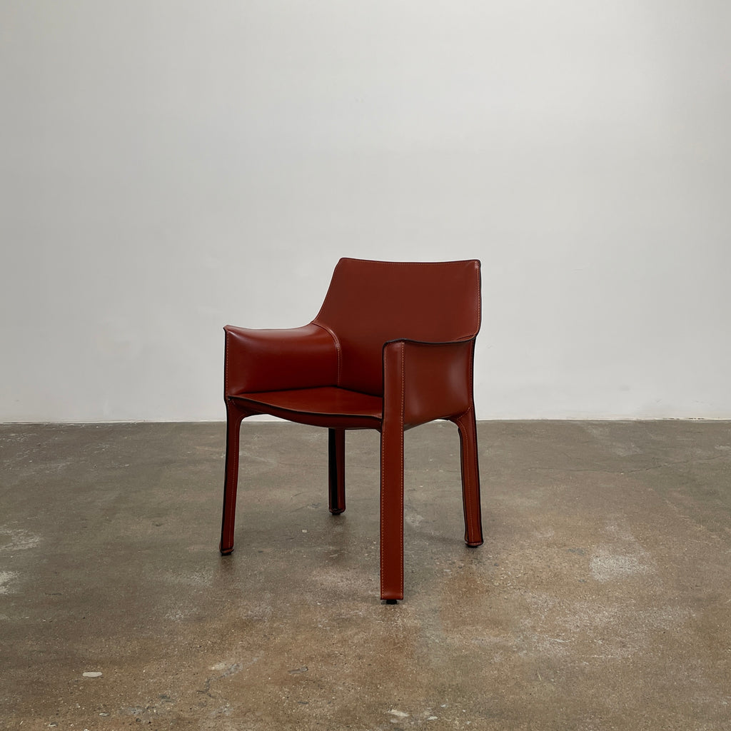 The Cassina Cab 413 Armchair in vibrant red leather presents a modern design with a high back and square legs, elegantly displayed against a plain white background.