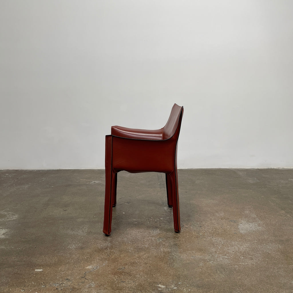 The Cassina Cab 413 Armchair in vibrant red leather presents a modern design with a high back and square legs, elegantly displayed against a plain white background.