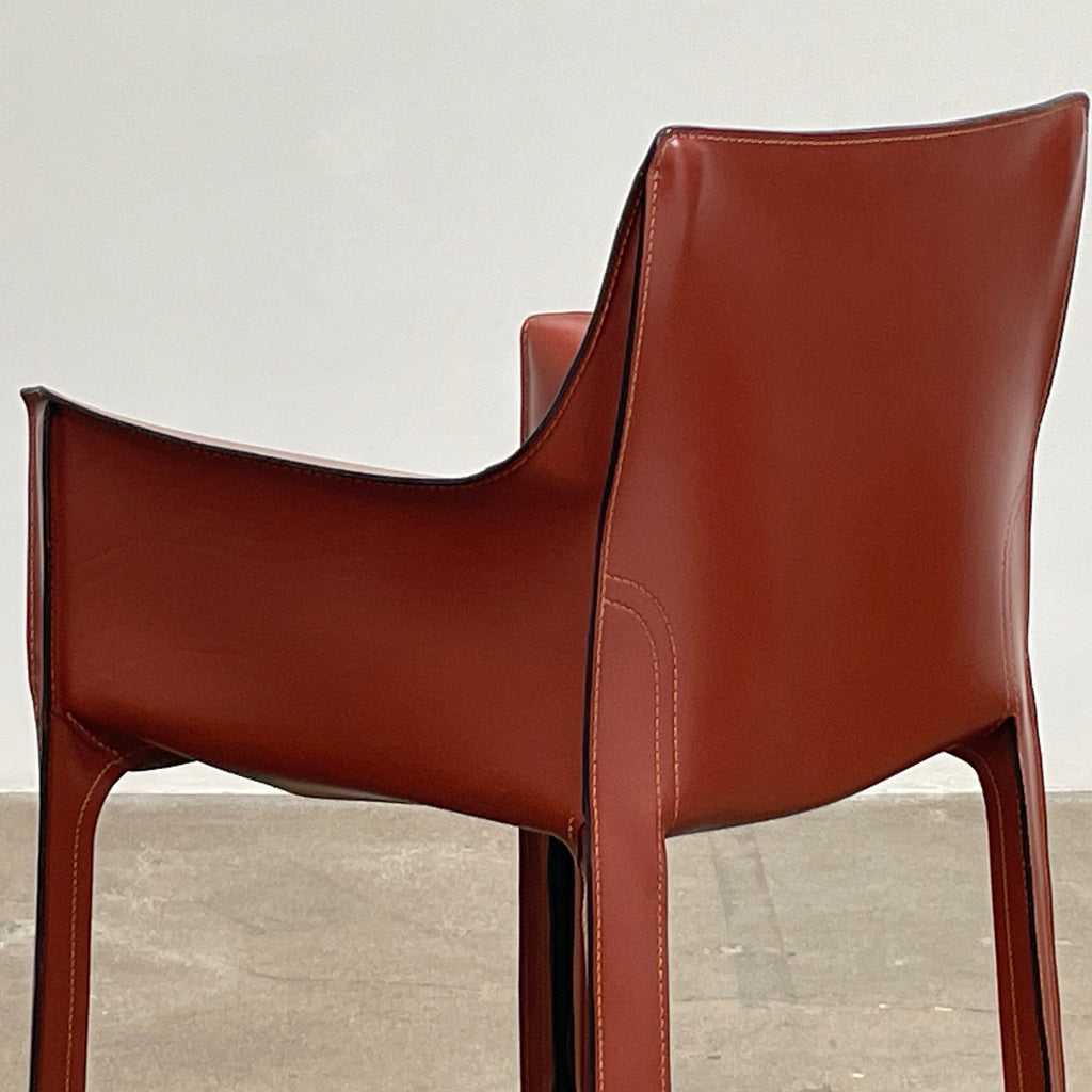 The Cassina Cab 413 Armchair in vibrant red leather presents a modern design with a high back and square legs, elegantly displayed against a plain white background.