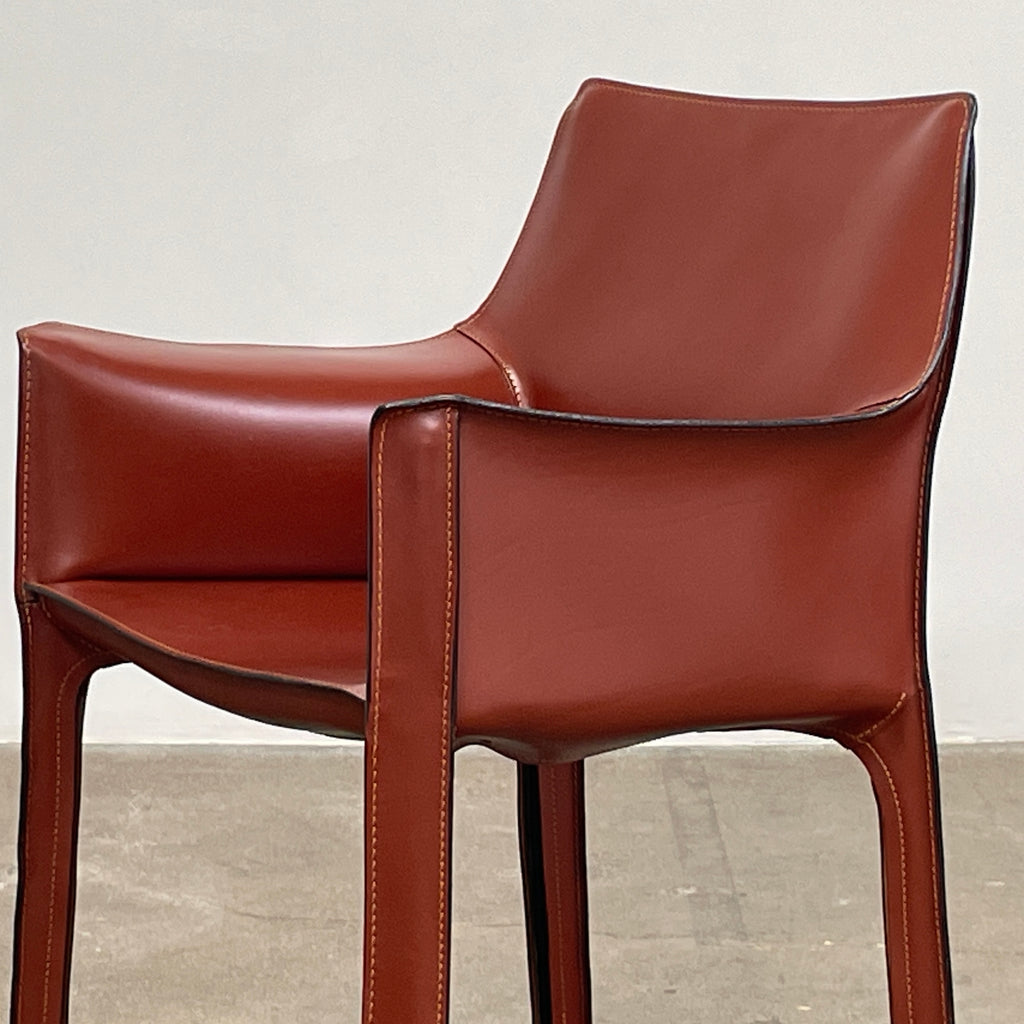 The Cassina Cab 413 Armchair in vibrant red leather presents a modern design with a high back and square legs, elegantly displayed against a plain white background.