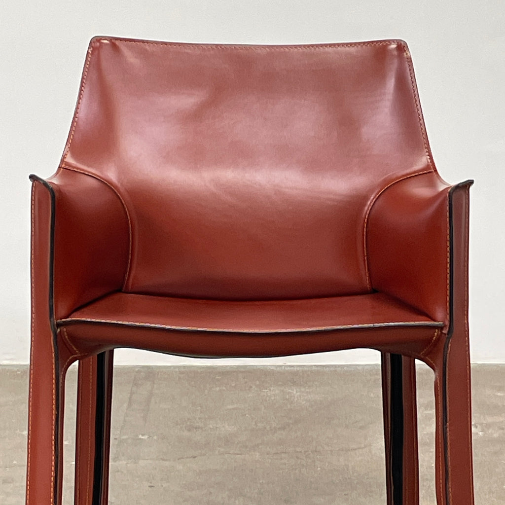 The Cassina Cab 413 Armchair in vibrant red leather presents a modern design with a high back and square legs, elegantly displayed against a plain white background.