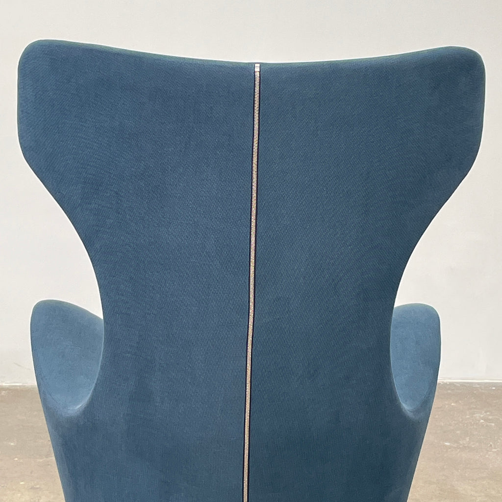 A modern, dark blue B&B Italia Grande Papilio Swivel Chair by Naoto Fukasawa showcases a curved design with a high backrest and wide seat, set against a plain white background.