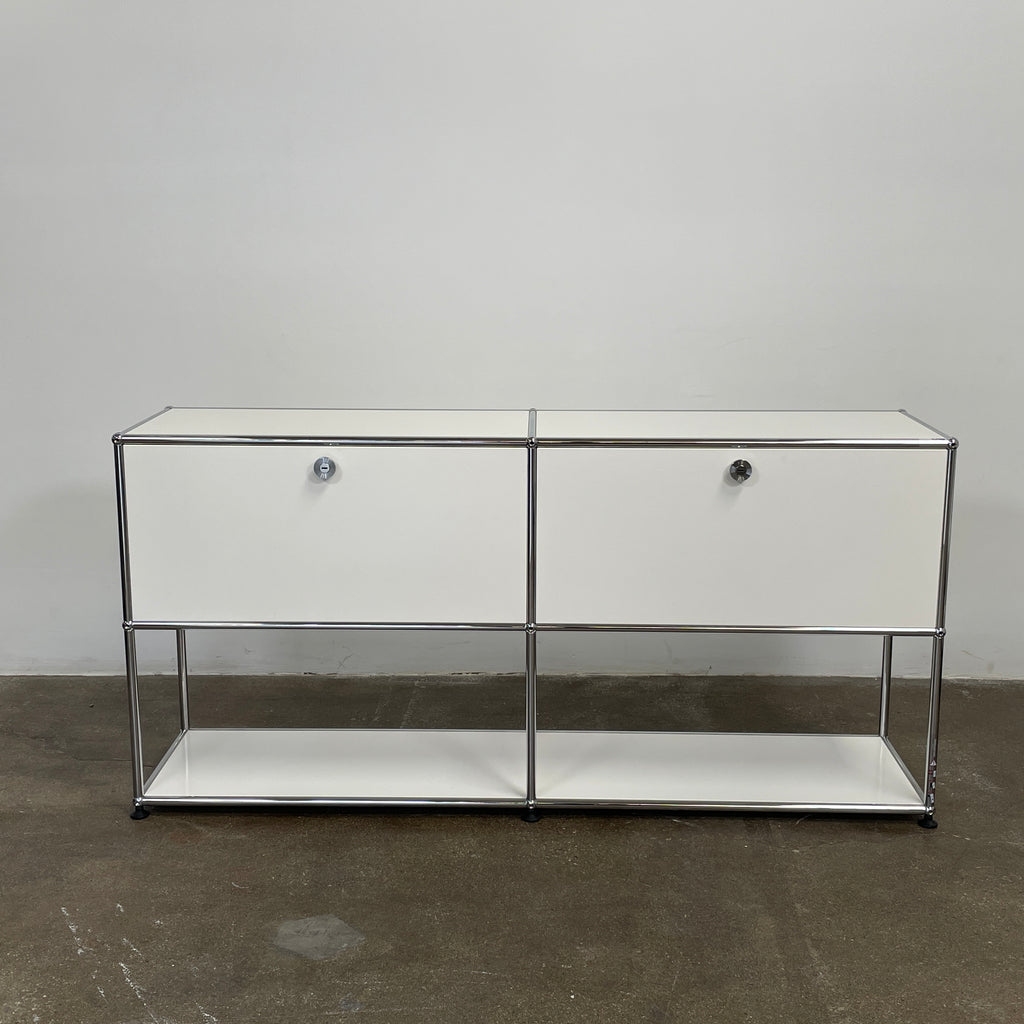 The modern USM Haller Open Credenza in white showcases two compartments with round metal handles and an open lower shelf for display, effortlessly combining functionality with contemporary design.