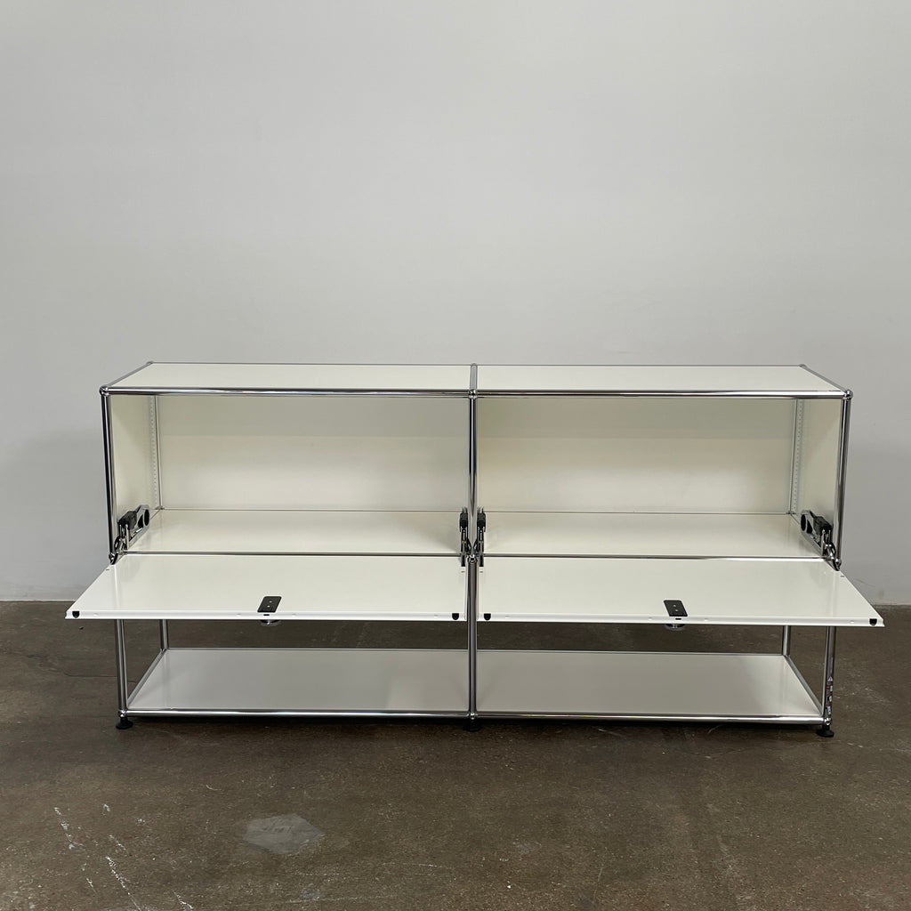 The modern USM Haller Open Credenza in white showcases two compartments with round metal handles and an open lower shelf for display, effortlessly combining functionality with contemporary design.