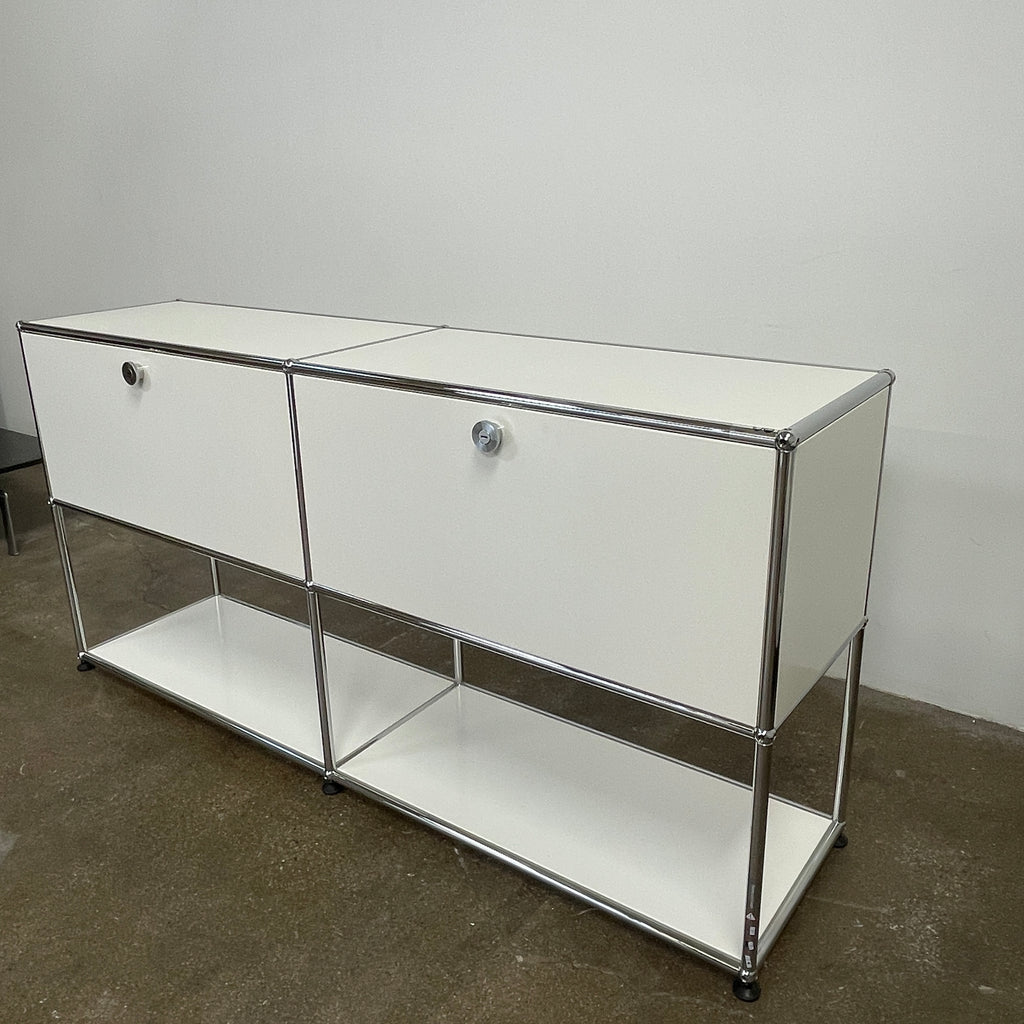 The modern USM Haller Open Credenza in white showcases two compartments with round metal handles and an open lower shelf for display, effortlessly combining functionality with contemporary design.