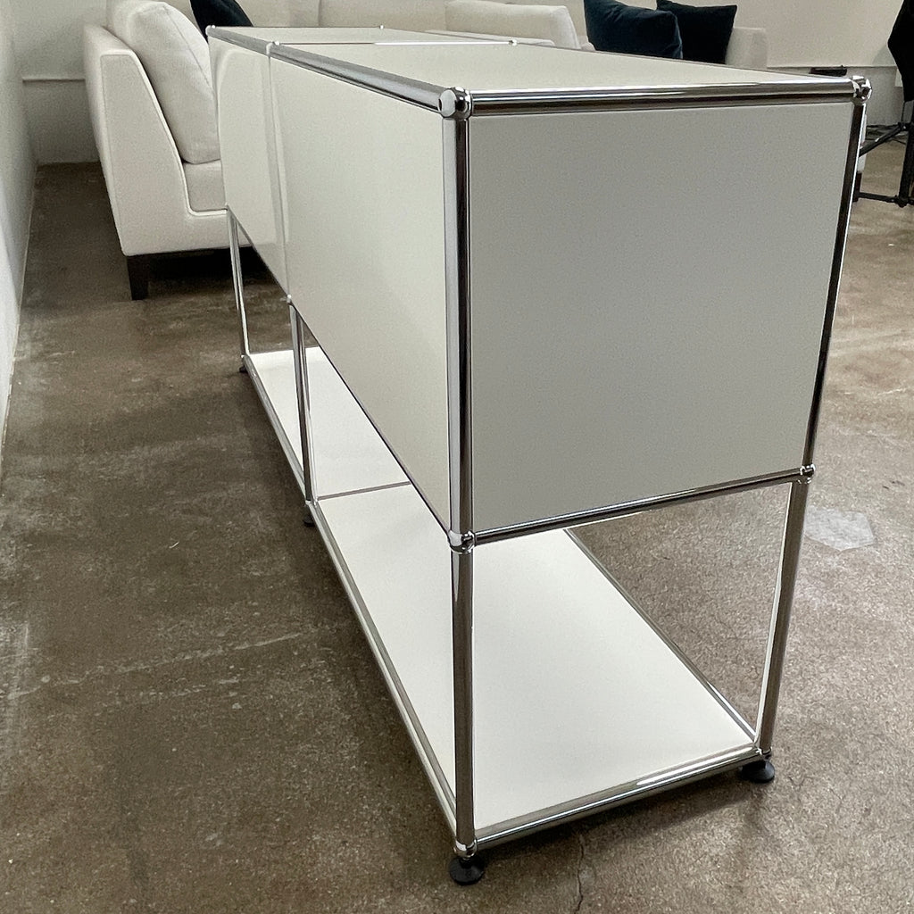 The modern USM Haller Open Credenza in white showcases two compartments with round metal handles and an open lower shelf for display, effortlessly combining functionality with contemporary design.