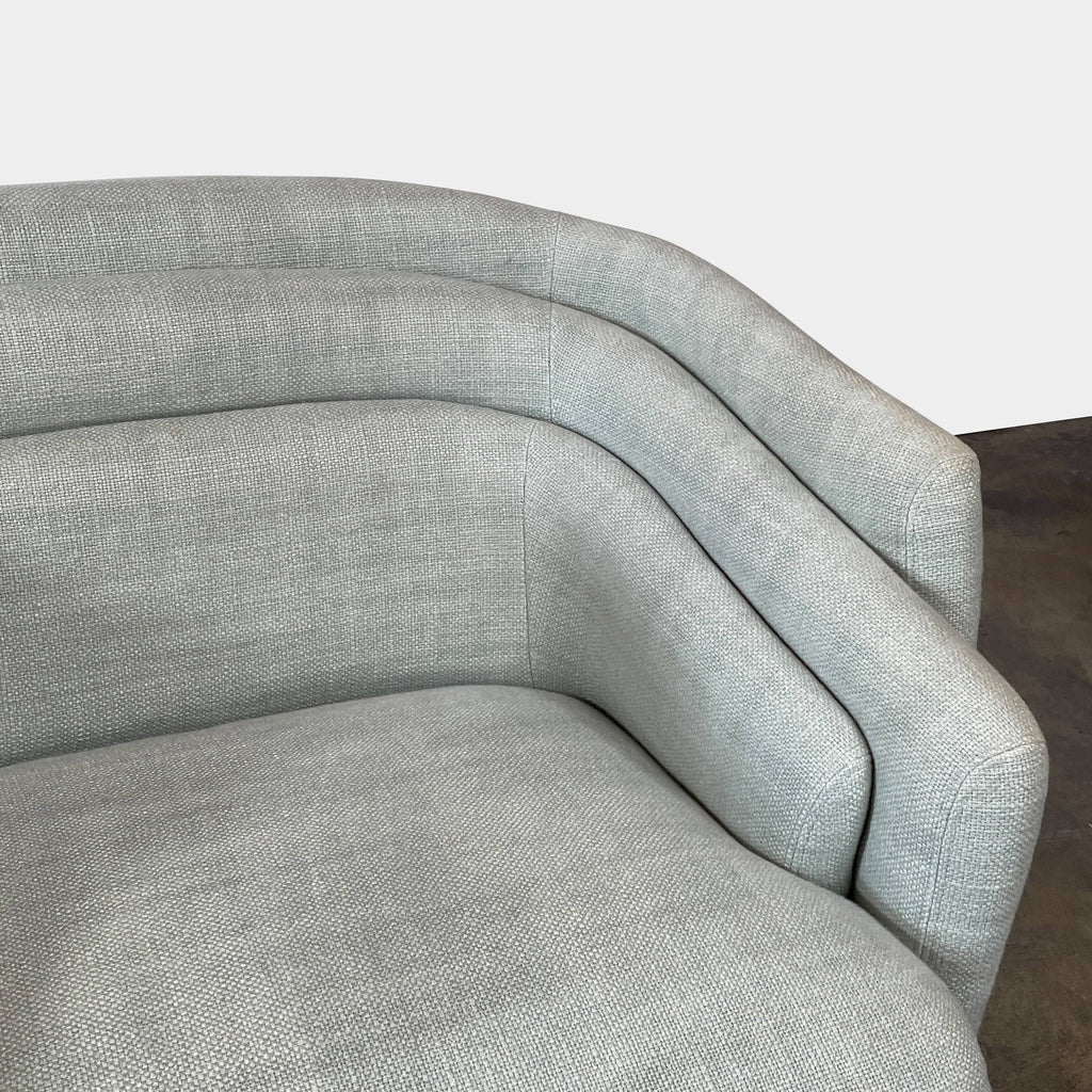 The Delcourt Collection Hug Armchair, upholstered in a delightful light blue fabric, features sleek black legs.