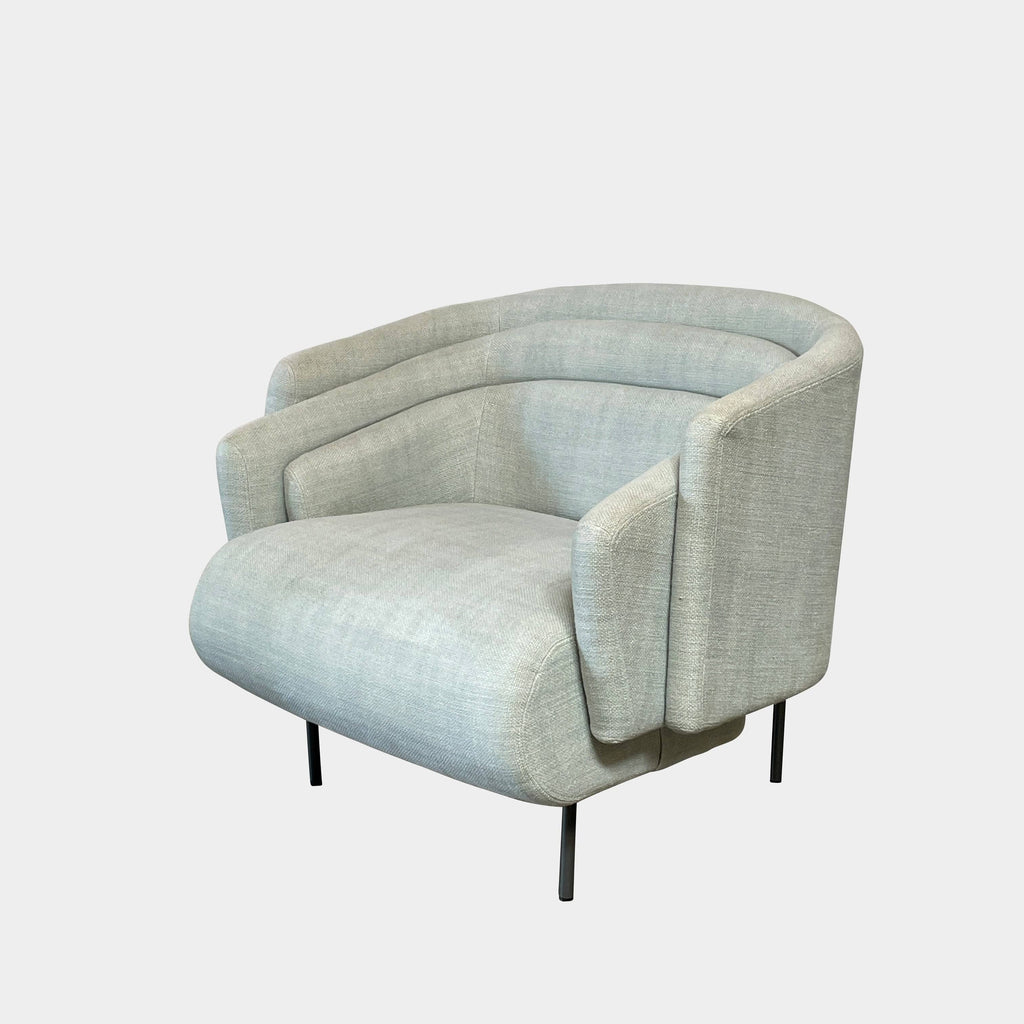 The Delcourt Collection Hug Armchair, upholstered in a delightful light blue fabric, features sleek black legs.