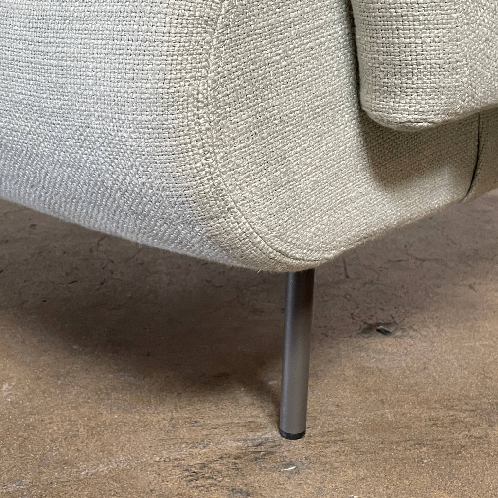 The Delcourt Collection Hug Armchair, upholstered in a delightful light blue fabric, features sleek black legs.