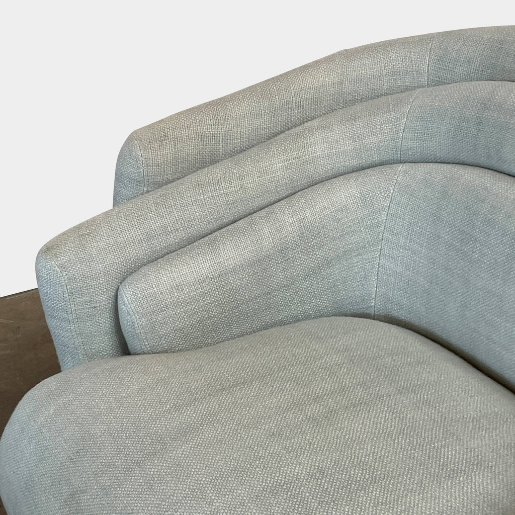 The Delcourt Collection Hug Armchair, upholstered in a delightful light blue fabric, features sleek black legs.