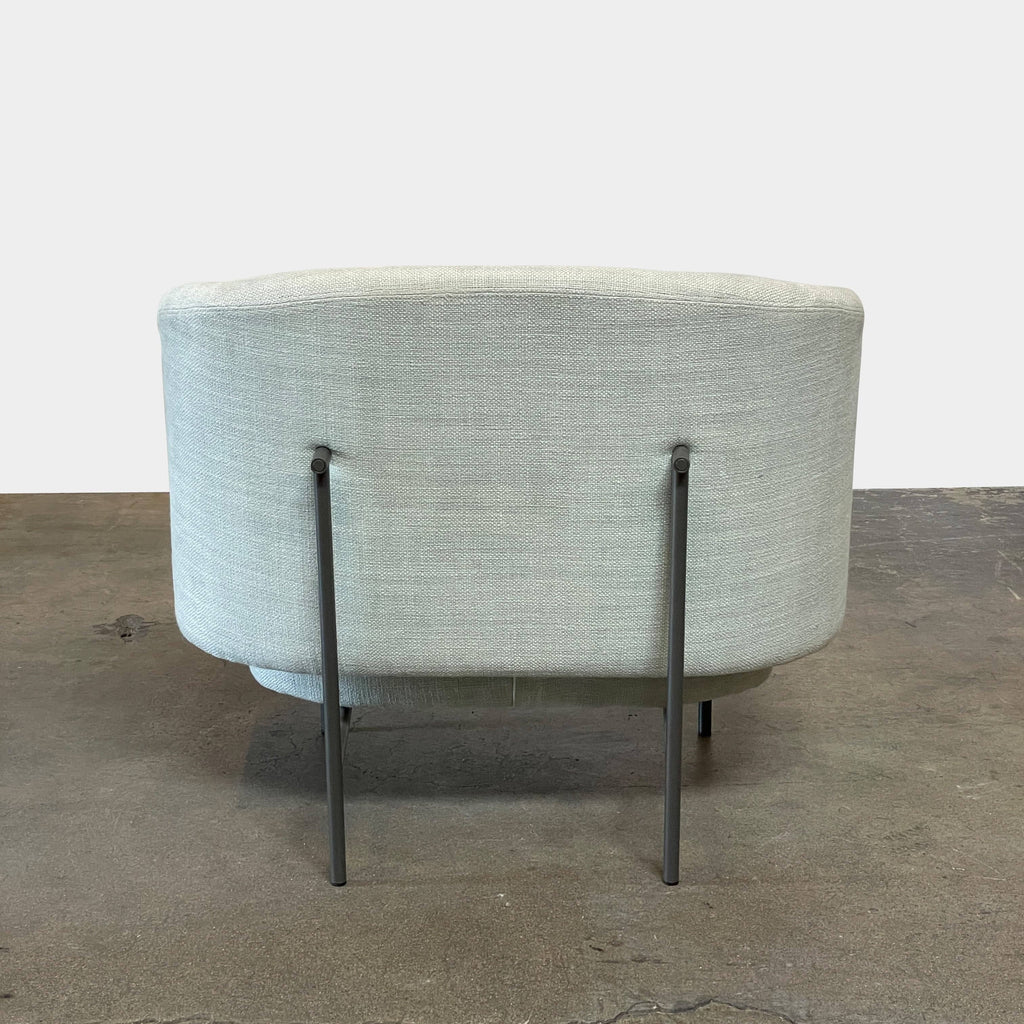 The Delcourt Collection Hug Armchair, upholstered in a delightful light blue fabric, features sleek black legs.