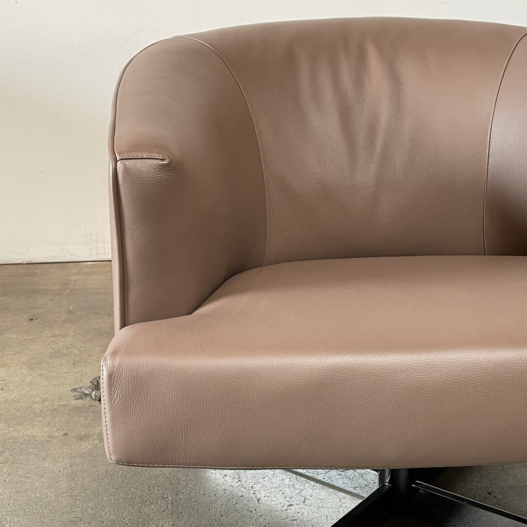 A Minotti Martin Brown Leather Swivel Chair with a cushioned seat and back, sitting on a sleek black chrome base, against a plain white background.