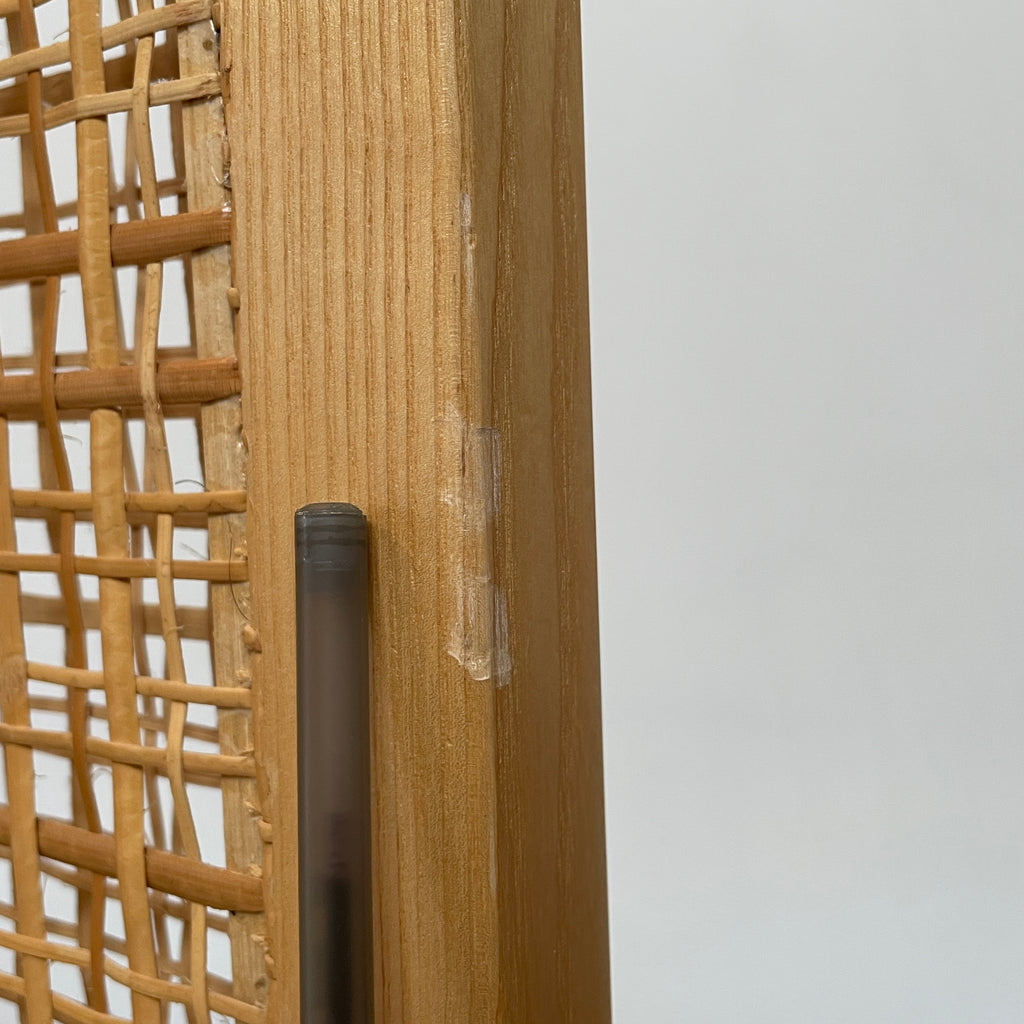 Close-up view of a wooden frame with a woven wicker panel, showcasing Lebanese craftsmanship. The wood shows a small patch of wear, offering a glimpse into the meticulous detailing associated with Nada Debs' contemporary Arabesque designs in the Nada Debs Summerland Folding Screen.