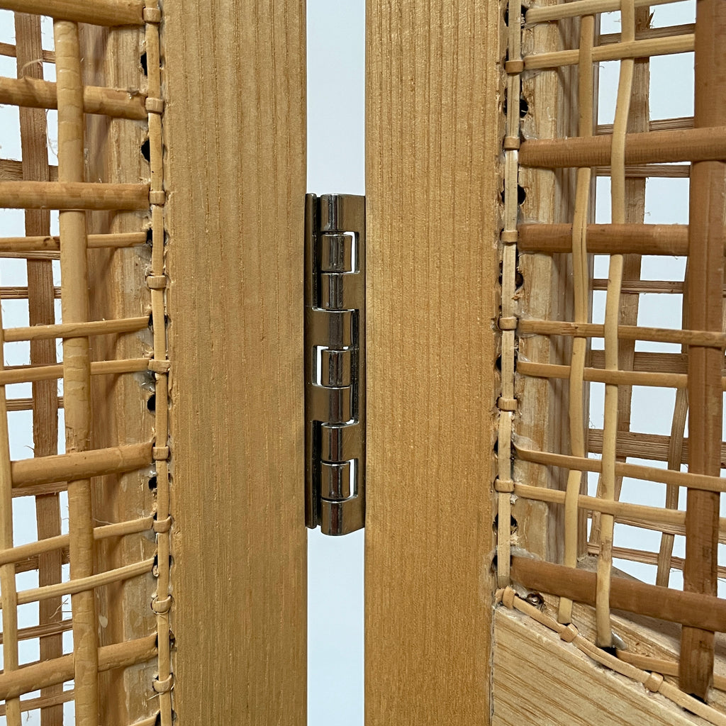 Close-up view of a wooden frame with a woven wicker panel, showcasing Lebanese craftsmanship. The wood shows a small patch of wear, offering a glimpse into the meticulous detailing associated with Nada Debs' contemporary Arabesque designs in the Nada Debs Summerland Folding Screen.