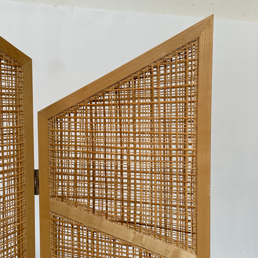 Close-up view of a wooden frame with a woven wicker panel, showcasing Lebanese craftsmanship. The wood shows a small patch of wear, offering a glimpse into the meticulous detailing associated with Nada Debs' contemporary Arabesque designs in the Nada Debs Summerland Folding Screen.