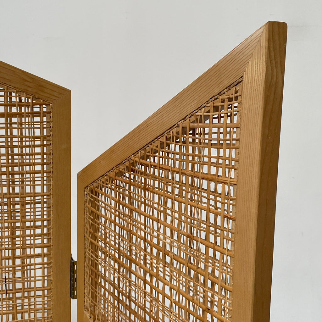 Close-up view of a wooden frame with a woven wicker panel, showcasing Lebanese craftsmanship. The wood shows a small patch of wear, offering a glimpse into the meticulous detailing associated with Nada Debs' contemporary Arabesque designs in the Nada Debs Summerland Folding Screen.