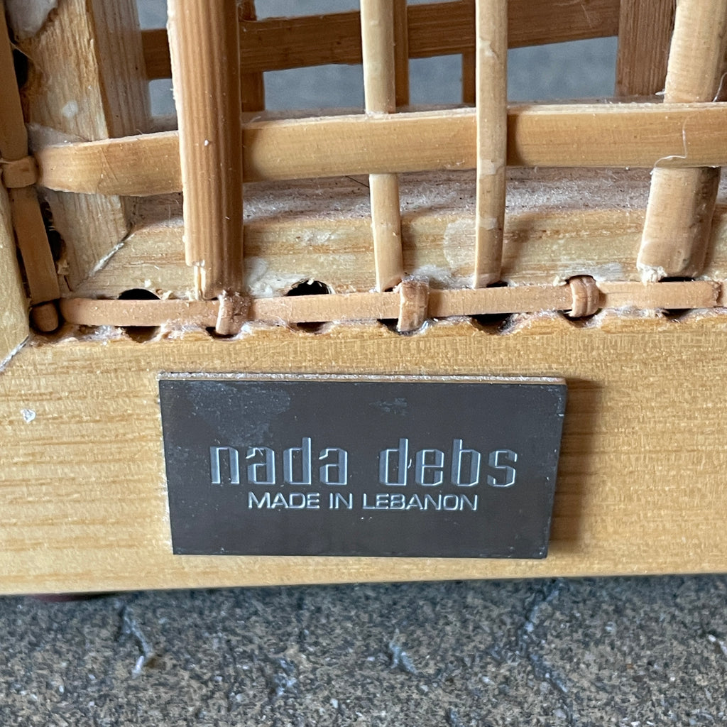 Close-up view of a wooden frame with a woven wicker panel, showcasing Lebanese craftsmanship. The wood shows a small patch of wear, offering a glimpse into the meticulous detailing associated with Nada Debs' contemporary Arabesque designs in the Nada Debs Summerland Folding Screen.