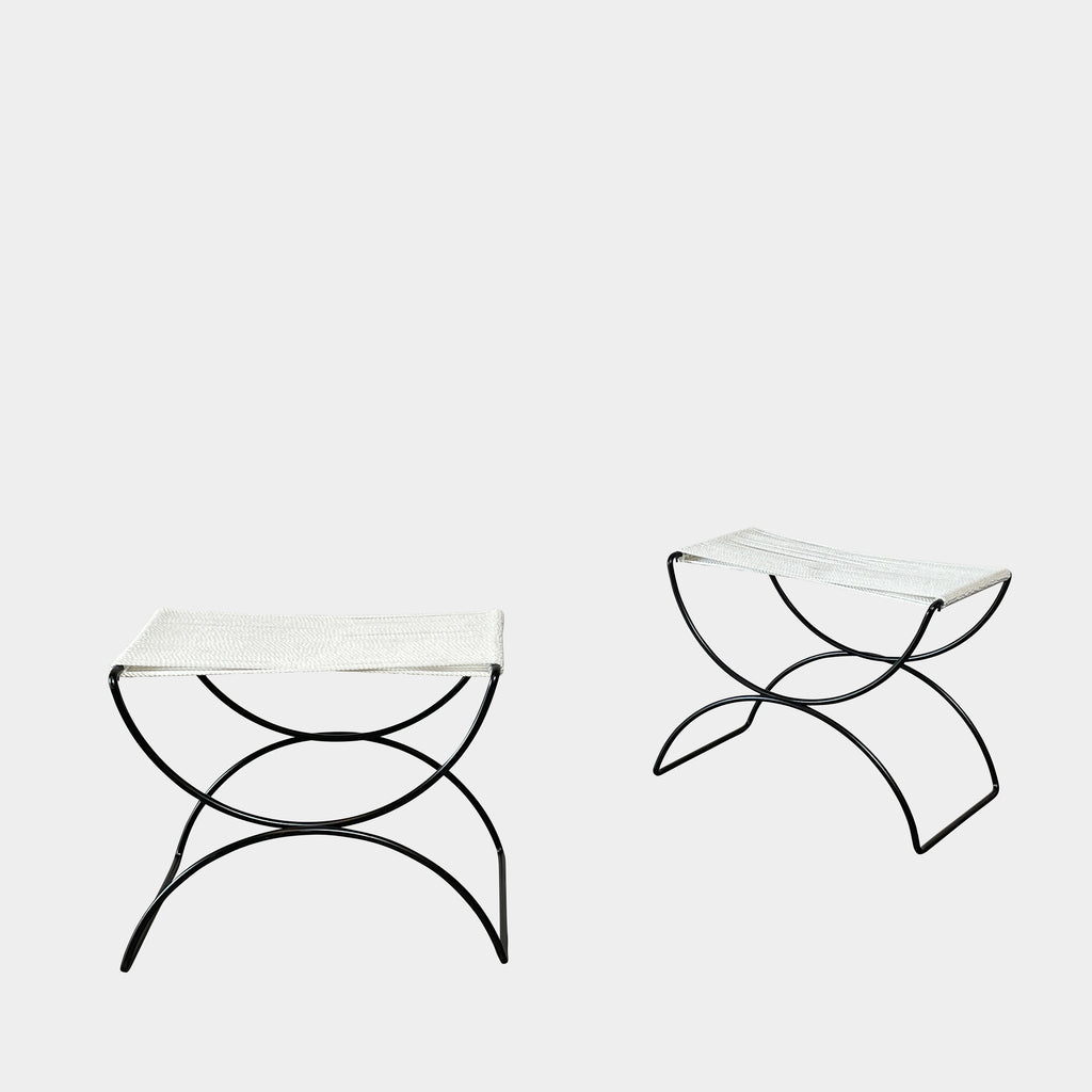 Two TEN10 Pompeii Low Outdoor Stools by TEN10 with mid-century modernist design feature curved black wrought iron bases and white, fabric-covered seats set against a plain white background.