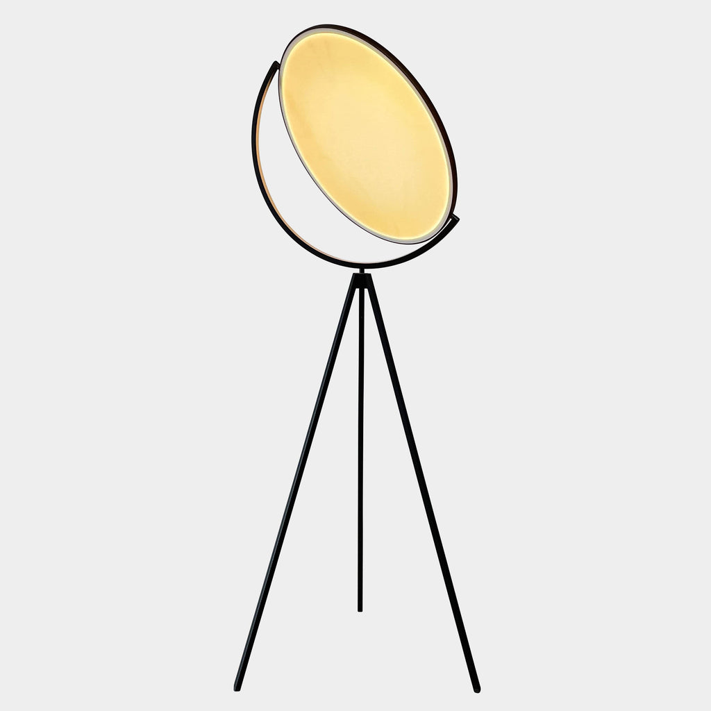 A large circular mirror set in a black metal frame on a tripod stand, isolated against a white background, exudes sophistication akin to the Flos Superloon Floor Light by Flos, providing broad and diffused light that can be dimmed for any ambiance.