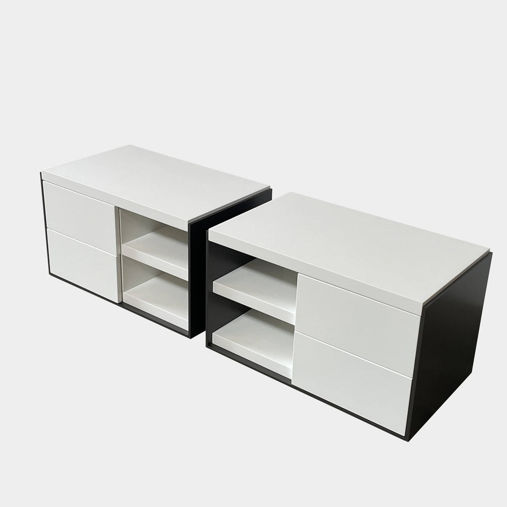 Two identical B&B Italia Surface Nightstands by B&B Italia, in a chic white finish with black trim, each featuring two drawers and open shelving in the middle. These modern pieces are perfect for any contemporary bedroom furniture arrangement.