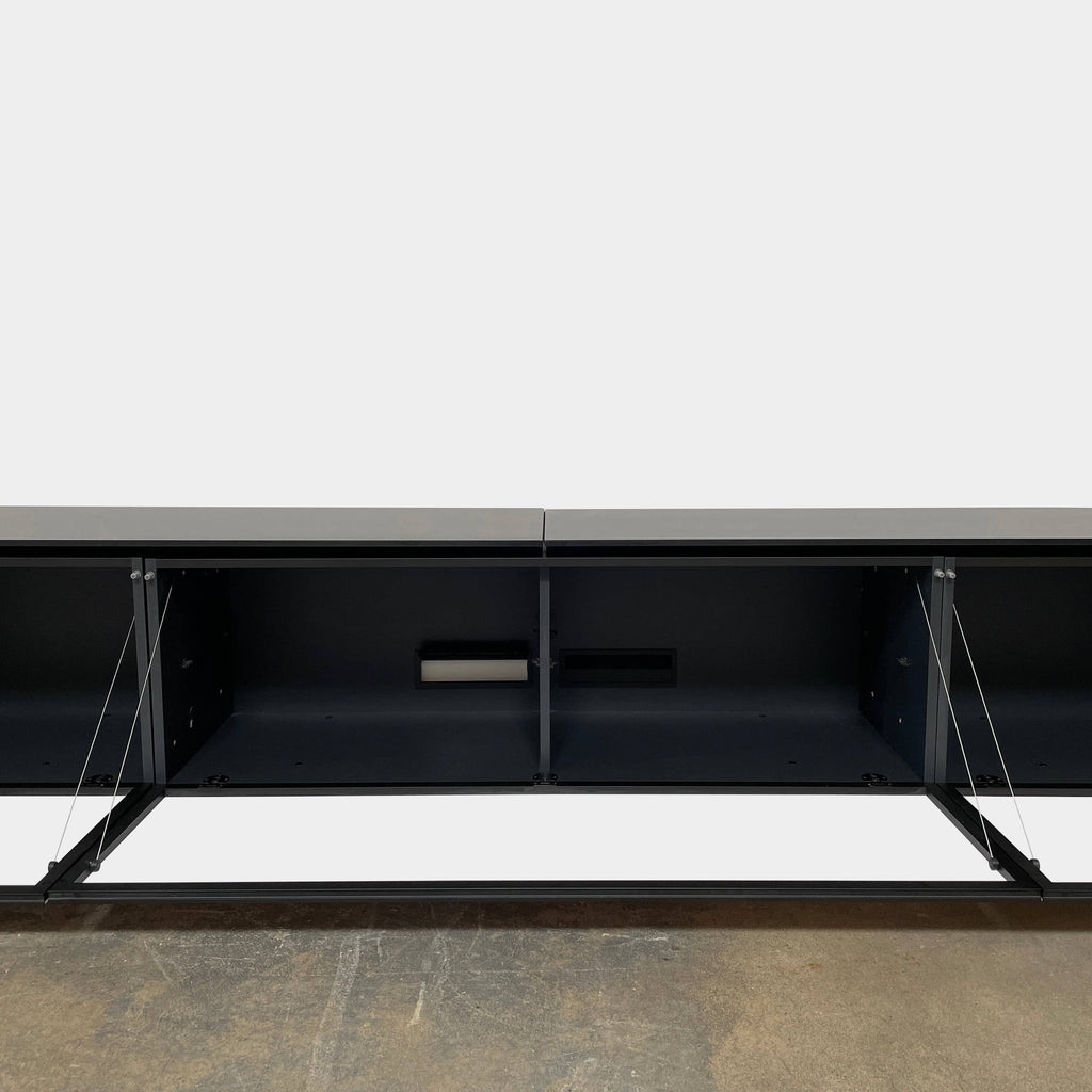 A low, modern white sideboard with a sleek black top and three compartments offers ample storage, set against a plain white background. The B&B Italia Pab Low Console by B&B Italia boasts a glossy finish that enhances its contemporary appeal.
