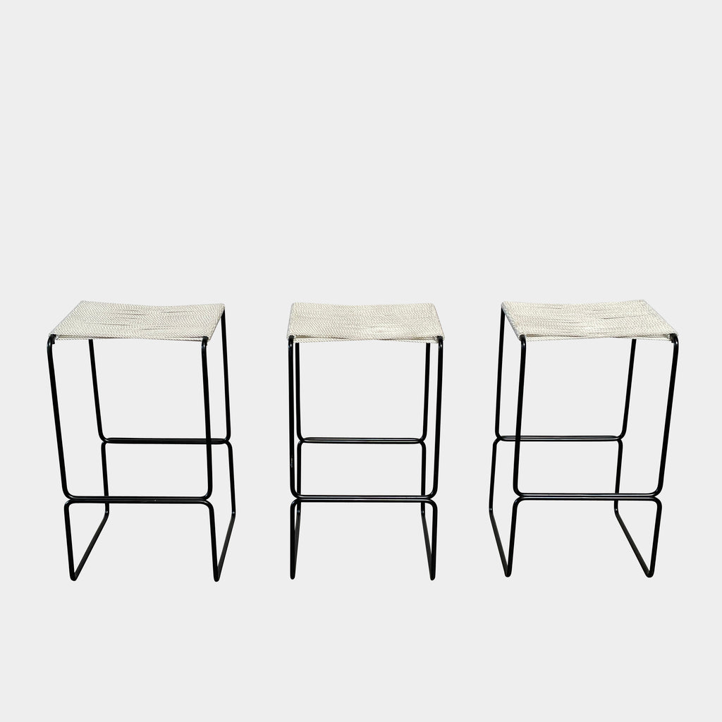 Three TEN10 Pompeii Counter Stool Set stools with black metal frames and woven white seats are lined up evenly against a plain white background, exuding a mid-century modernist elegance that would feel at home in any stylish Los Angeles furniture showroom.