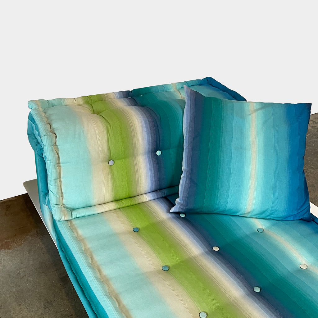 A modern, multicolored Roche Bobois Mah Jong Chaise Lounge from Roche Bobois with a gradient pattern in blue, green, and yellow shades, featuring a cushioned backrest and a matching pillow on a white base for perfect outdoor relaxation.