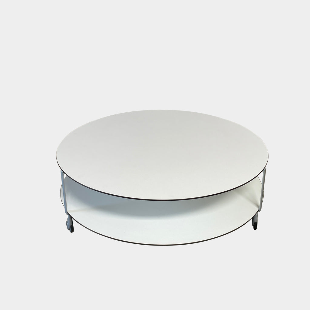 A Zanotta Giro Coffee Table, a round, white, two-tiered coffee table with a minimalist design, featuring a solid top and an open lower shelf for storage. The sleek steel frame adds durability, making it both stylish and functional.