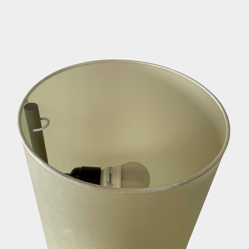 A modern, cone-shaped beige Pallucco Italia Abat Jour Floor Light by Pallucco Italia features a round base and a visible power cord, blending sleek design with Italian craftsmanship.