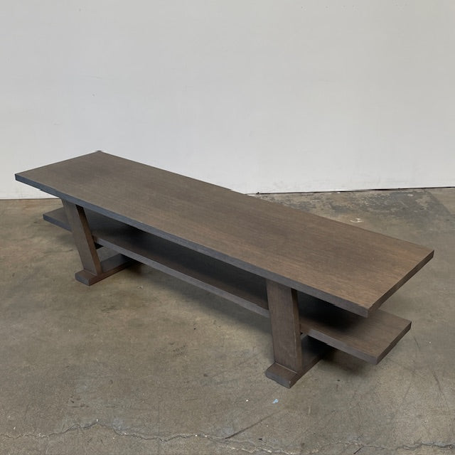 A wooden rectangular coffee table with a lower shelf and two supporting legs, reminiscent of a refined Maxalto Cicero Console by Maxalto.