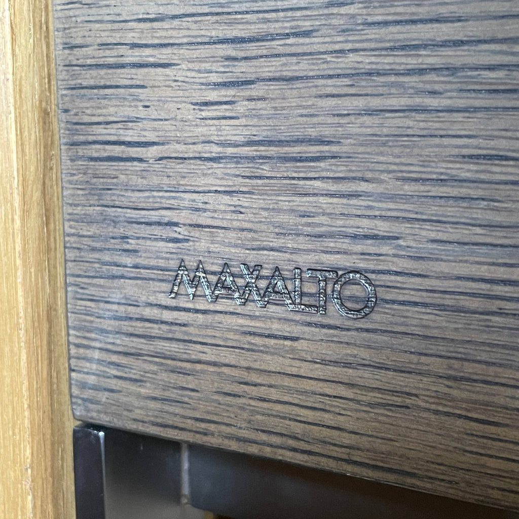 A Maxalto Mida High Cabinet featuring a brown wooden finish, two doors, and black metal legs stands elegantly against a white background.