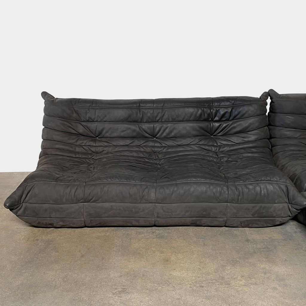 Ligne Roset Togo Three Piece Sectional, a black leather L-shaped sofa by Ligne Roset, features tufted cushions and a low backrest with polyether foam for enhanced comfort, beautifully displayed on a white background.