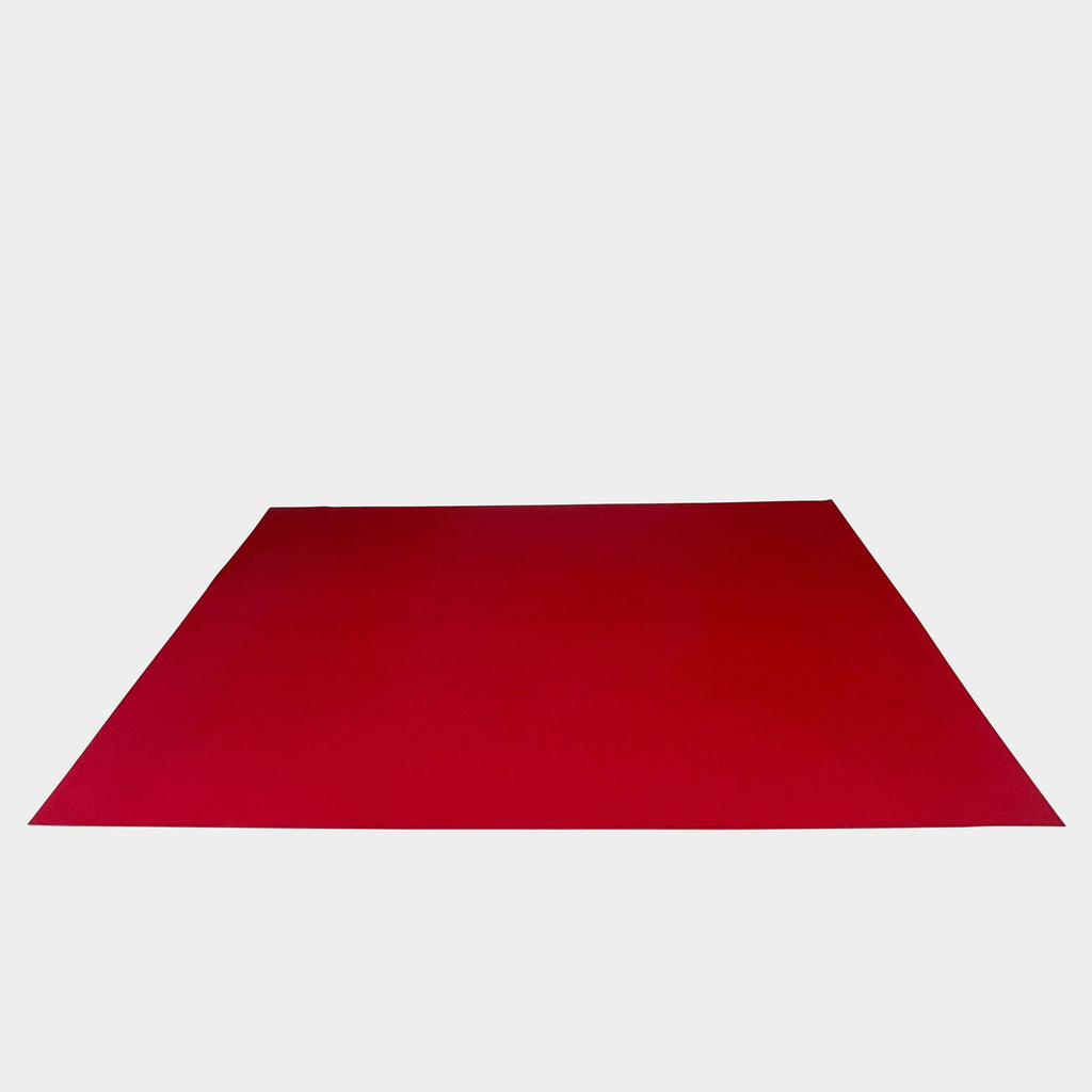 Close-up of the corner of a Large Felt Rug in a vibrant red color against a white background. The fabric showcases a clearly visible seam along its edge.