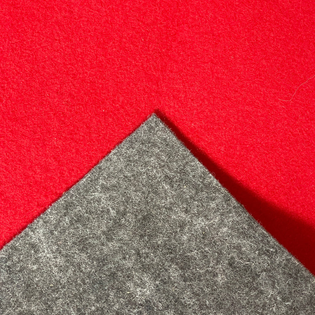 Close-up of the corner of a Large Felt Rug in a vibrant red color against a white background. The fabric showcases a clearly visible seam along its edge.