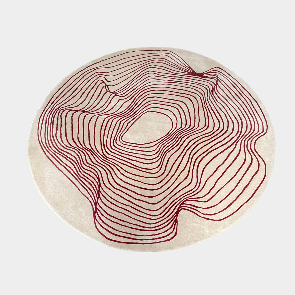 The Roche Bobois Volute Round Rug from Roche Bobois showcases a white surface decorated with red, wavy, parallel lines.