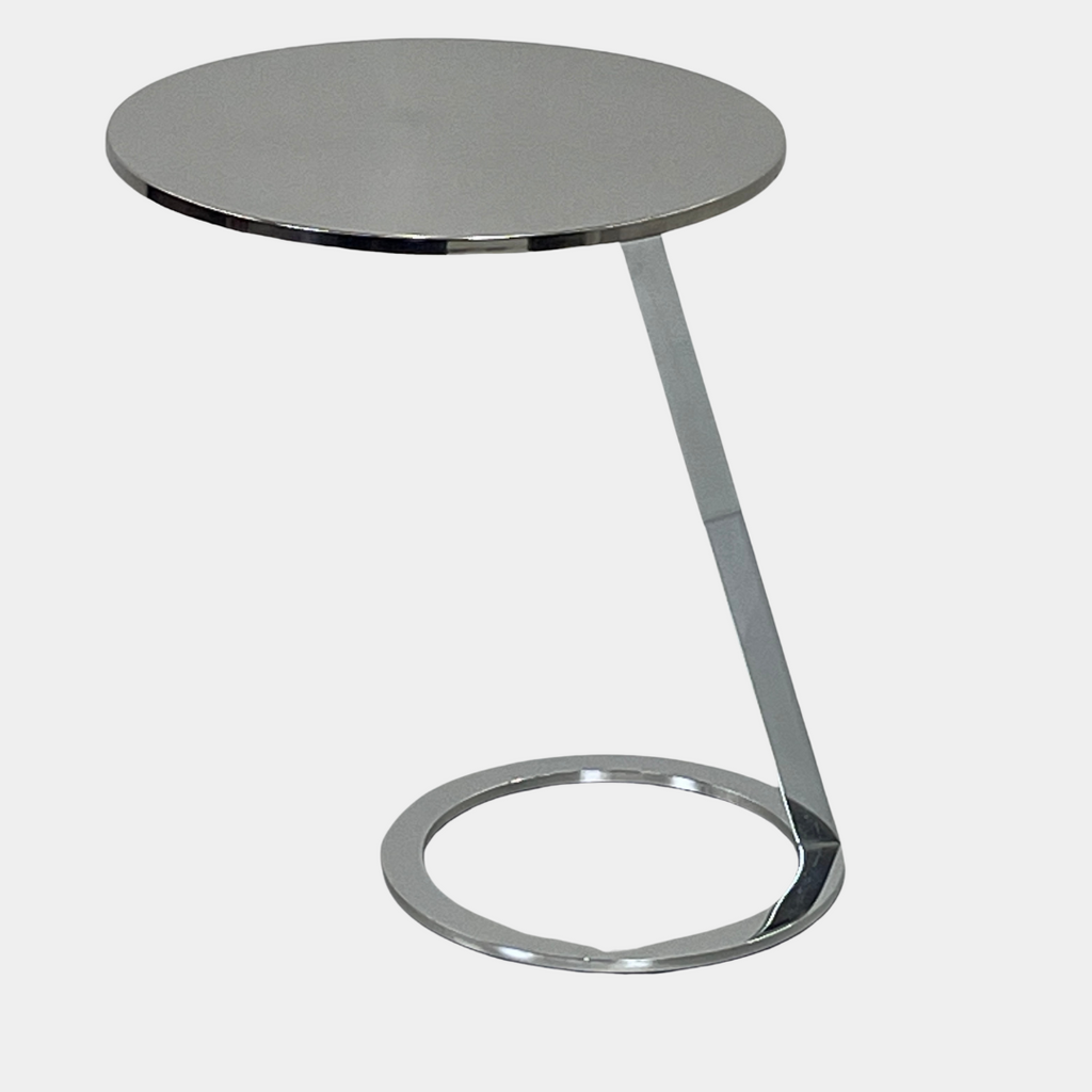 The Ligne Roset Good Morning Pedestal Side Table by Ligne Roset showcases a sleek, modern design with a round top and a distinctively angled chrome metal base on a circular foot.