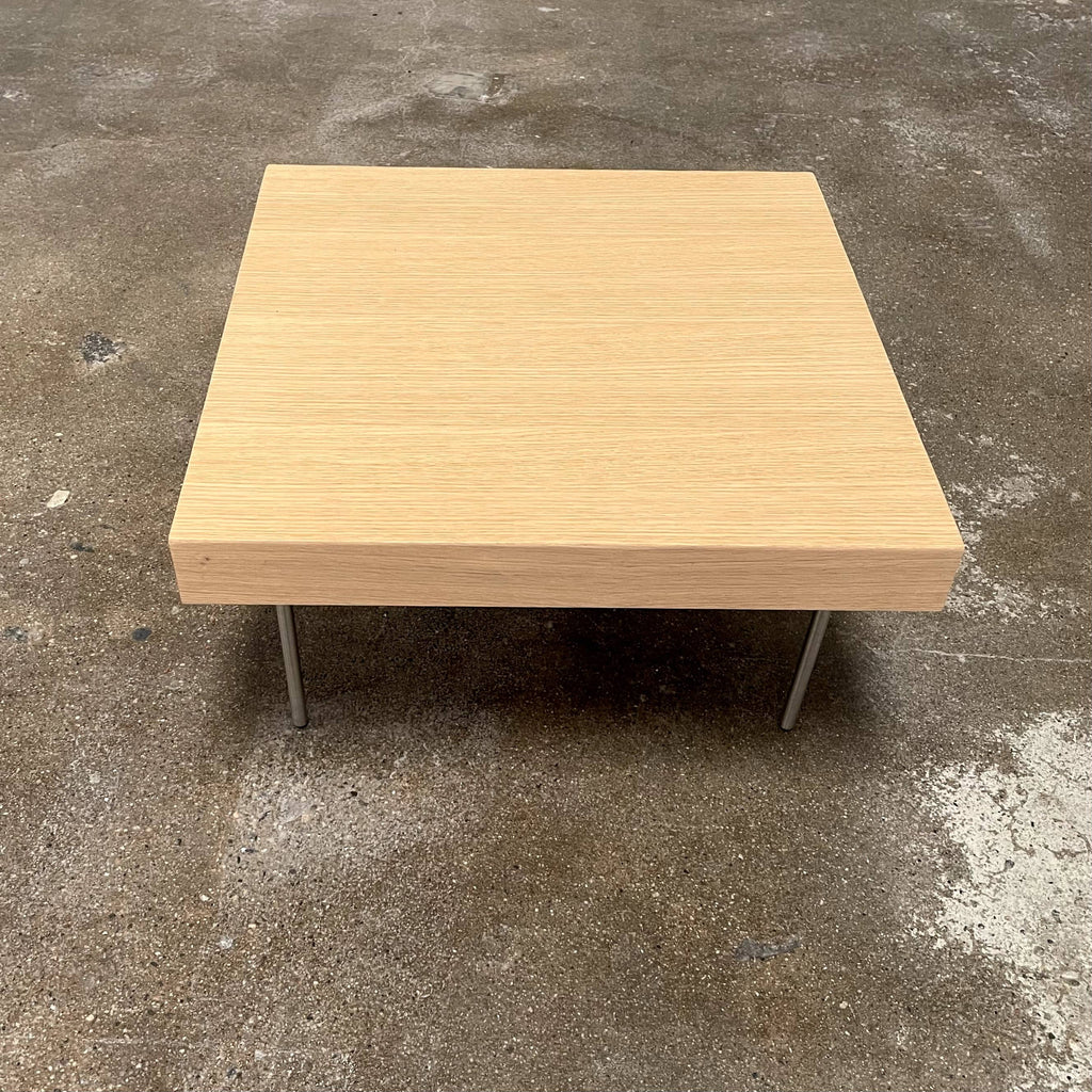 Ligne Roset Natural Wood Needle Table with metal legs on a plain white background, showcasing an elegant natural design.