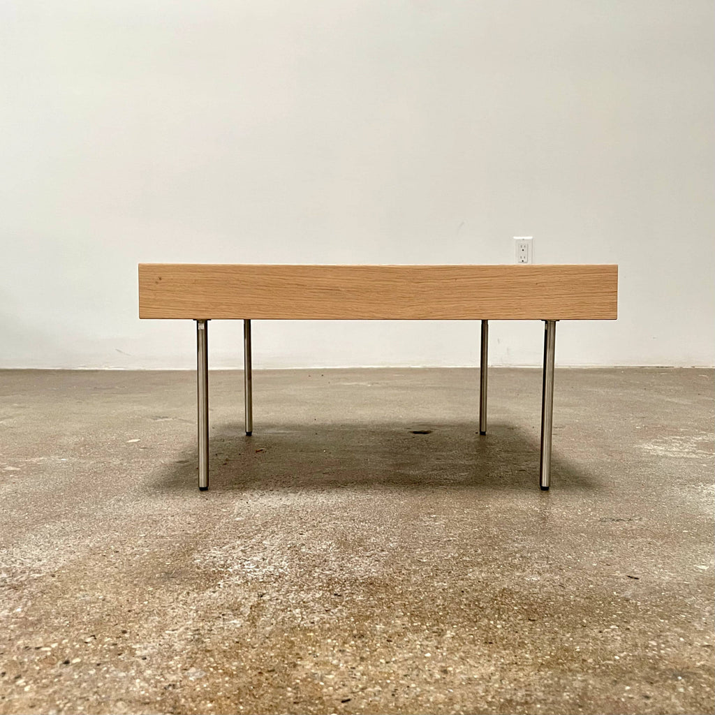 Ligne Roset Natural Wood Needle Table with metal legs on a plain white background, showcasing an elegant natural design.